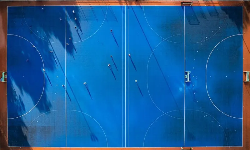 Quadra poliesportiva, pessoas jogando - representação simbólica do impacto gerado pela valorização das pequenas conquistas no consumo de experiências.