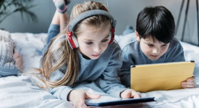 Geração Alfa: menina de aproximadamente 8 anos, com fone e tablet, representando a Geração Alfa.