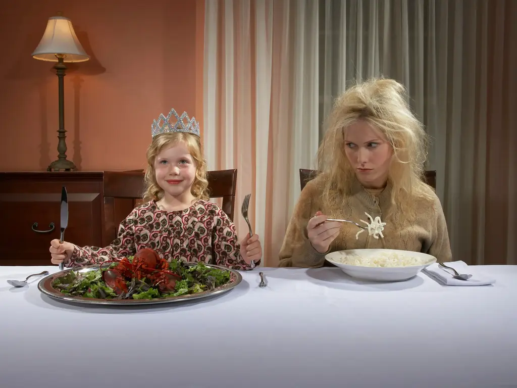 Mulher comendo prato calórico e se comparando com criança ai lado comendo um prato de salada.